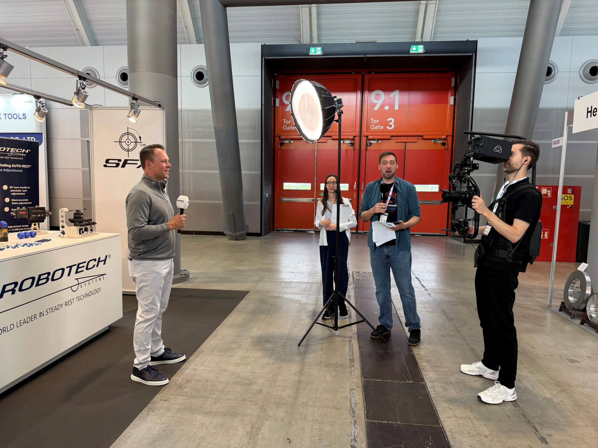 Person speaking in front of camera at Arobotech booth